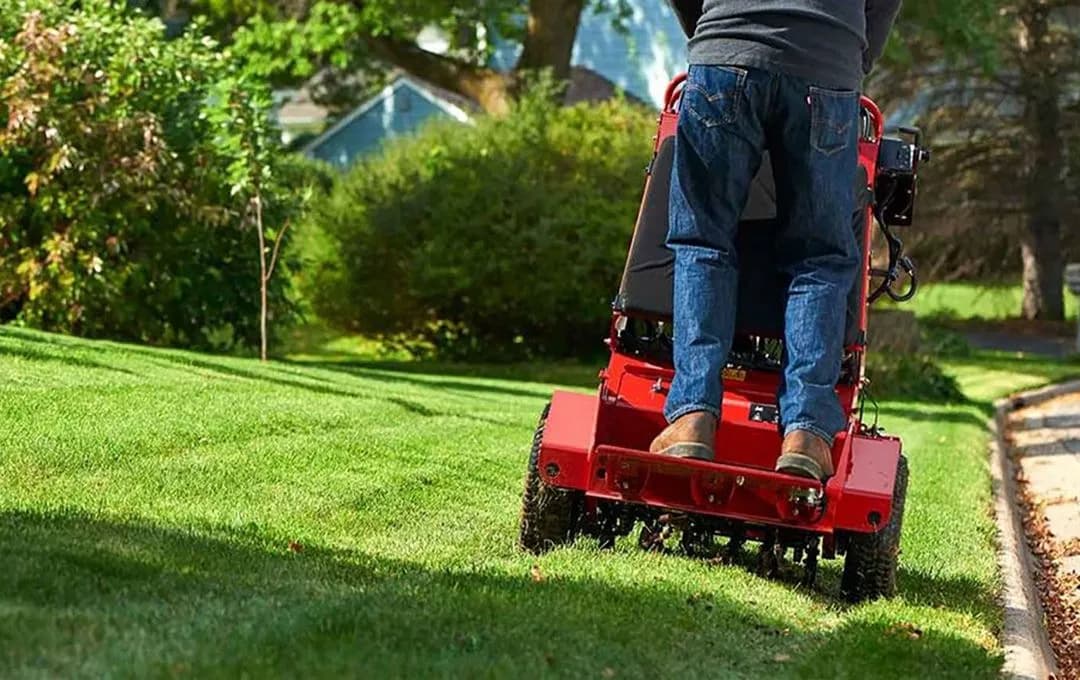 Man performing commercial maintenance on standing mower