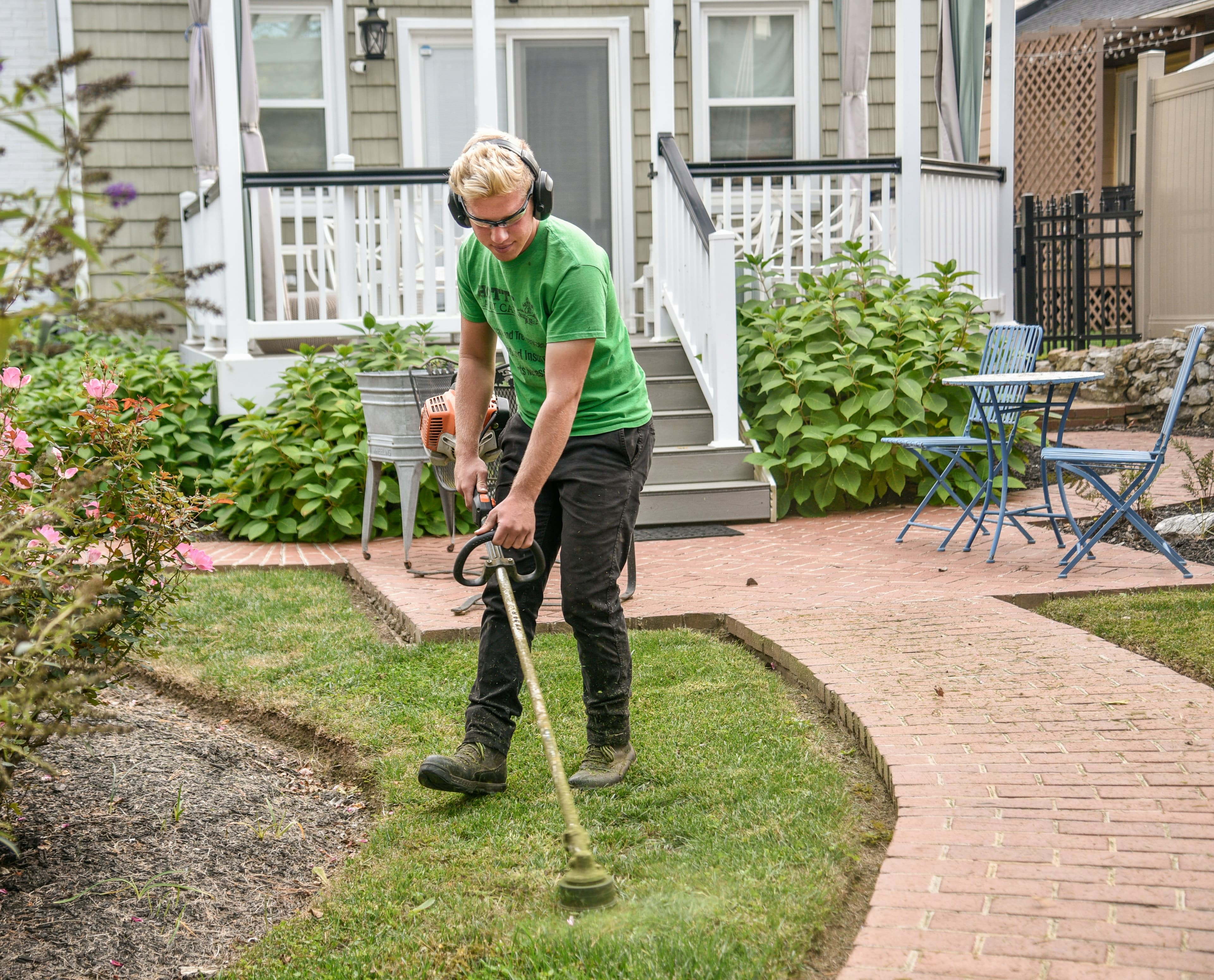 Man strimming grass in garden